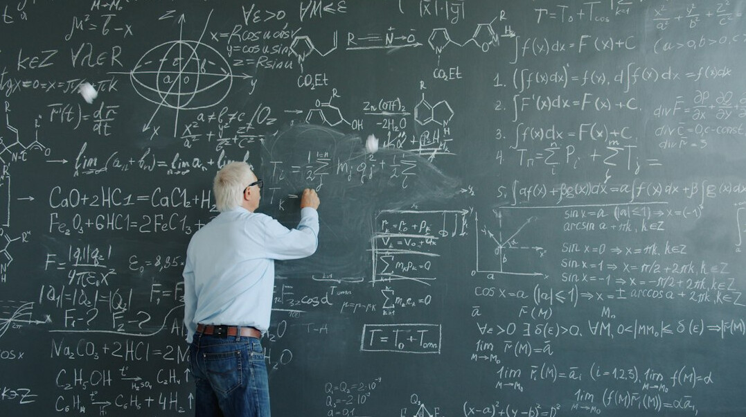 Researcher writing on a whiteboard with statistical formulas